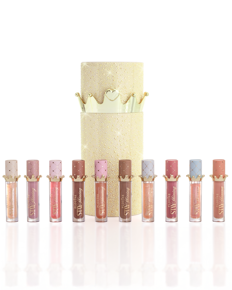 Ein Satz von zehn P.Louise Christmas Stay Shining Lip Oil-Produkten, in einer Reihe angeordnet, vor einer glitzernden goldenen zylindrischen Lippenölbox mit einem goldenen Kronendeckel, auf einem sauberen weißen Hintergrund.