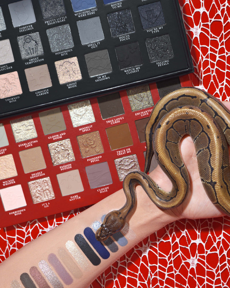 P.Louise Mystic Moonlight Halloween-Lidschatten- und Make-up-Palette mit Farbfeldern auf einem Arm, um den sich eine Schlange vor einem roten Spinnweben-Hintergrund wickelt