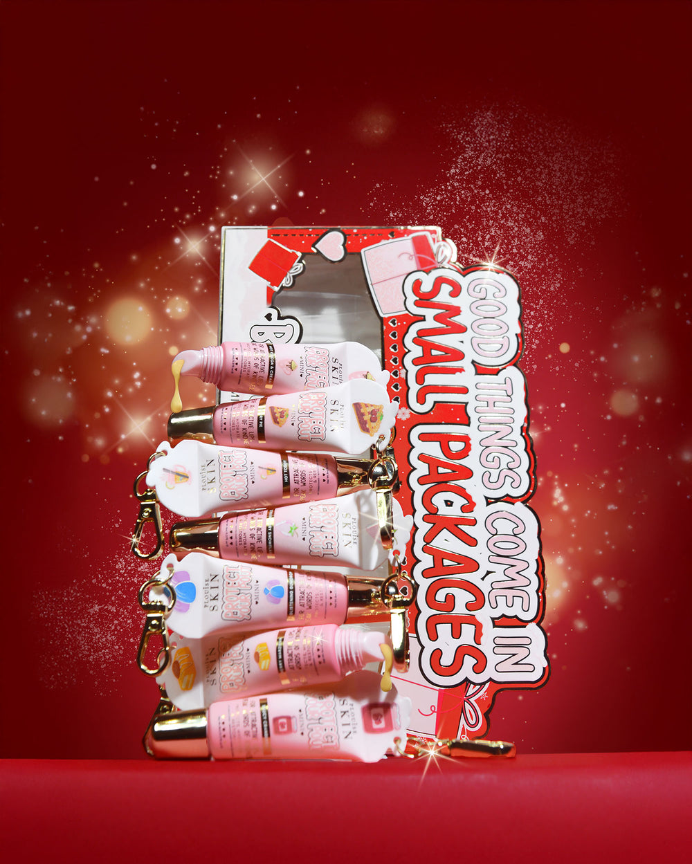 Set of 'All Good Things Come In Small Packages' mini lip conditioner gift set on a red background