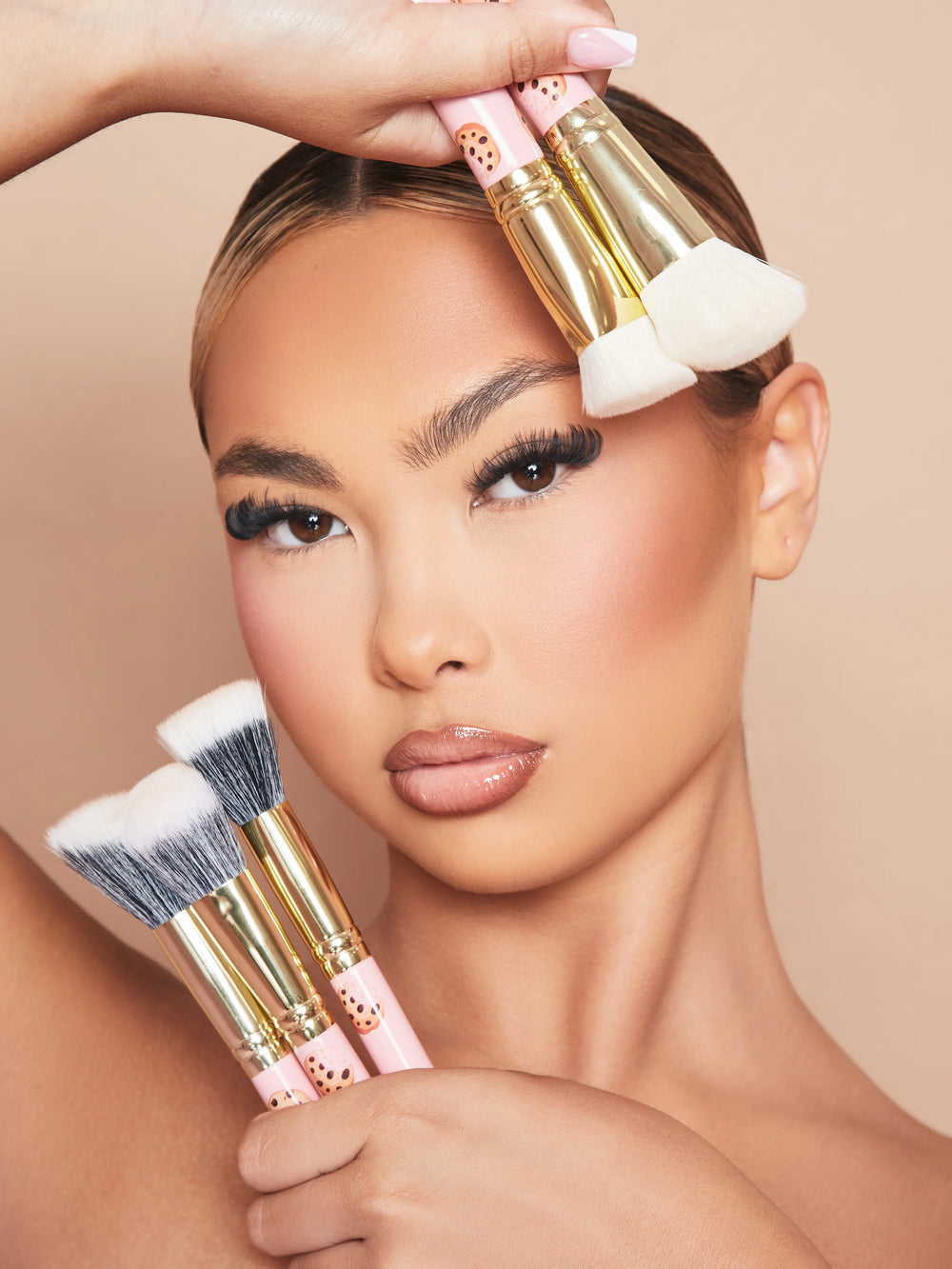 Una imagen de una modelo maquillada sosteniendo el juego de brochas de maquillaje de 5 piezas Spoiled For Choice de P.Louise contra su rostro.