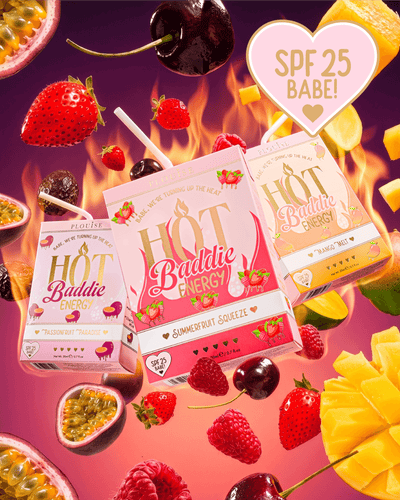 Drei Saftboxen von Hot Baddie Energy SPF Lip Conditioner und Lip Oil Duo sind in einer dynamischen, schwebenden Komposition angeordnet, umgeben von frischen Fruchtscheiben, Kirschen, Erdbeeren und Passionsfrüchten auf einem leuchtend rosa und orangefarbenen Hintergrund mit Flammengrafiken.