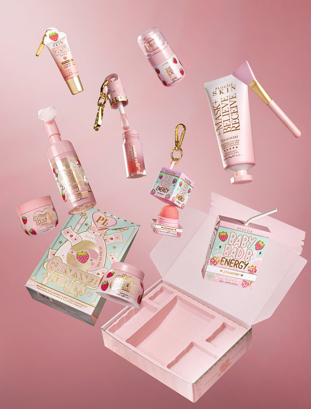 Die komplette Kollektion „P.Louise Strawberry Obsessed For Bad Bitch“ schwebt ausgepackt auf einem rosa Hintergrund