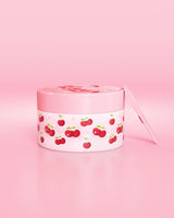 Contenedor rosa con diseño de cereza sobre fondo rosa
