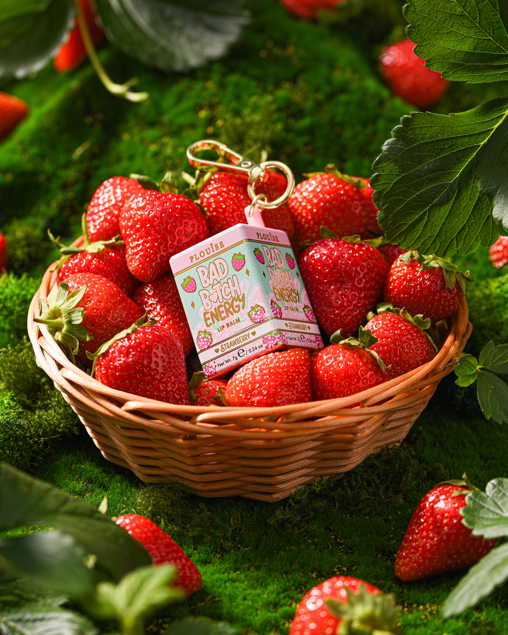 P.Louise Strawberry Schlüsselanhänger-Lippenbalsam in einem Korb mit Erdbeeren