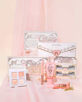 Set de maquillaje para novia You're Cordially Invited de P.Louise con packaging rosa y blanco sobre fondo rosa suave
