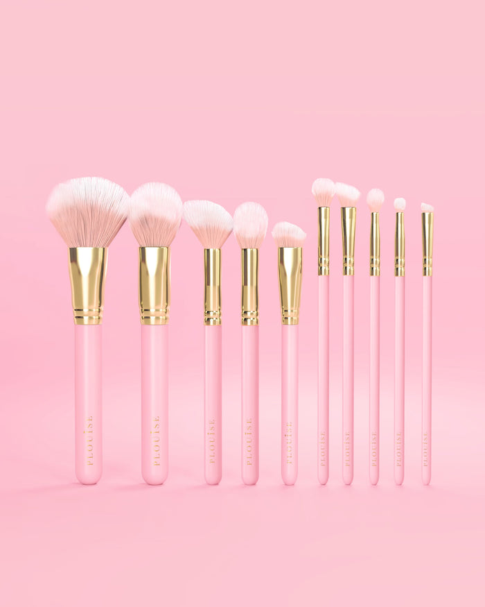 Set mit 10 rosa P.Louise-Make-up-Pinseln mit rosa Griffen und goldenen Akzenten auf rosa Hintergrund