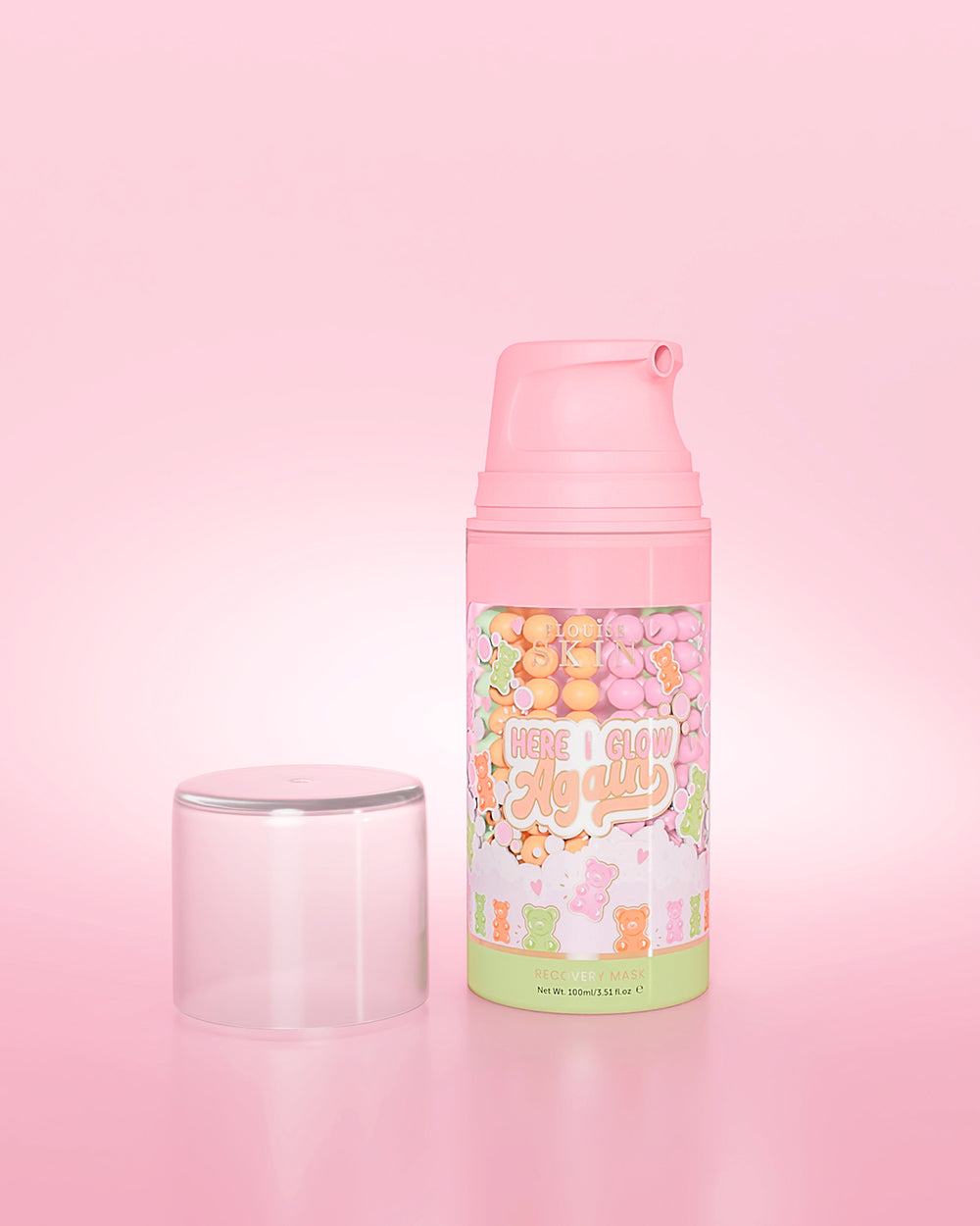 Botella morada de P. Louise Here I Glow Again Candy Bears Recovery Mask sobre un fondo rosa