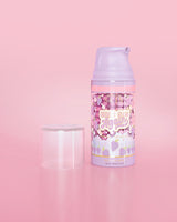 Botella morada de P. Louise Here I Glow Again Grape Recovery Mask sobre un fondo rosa