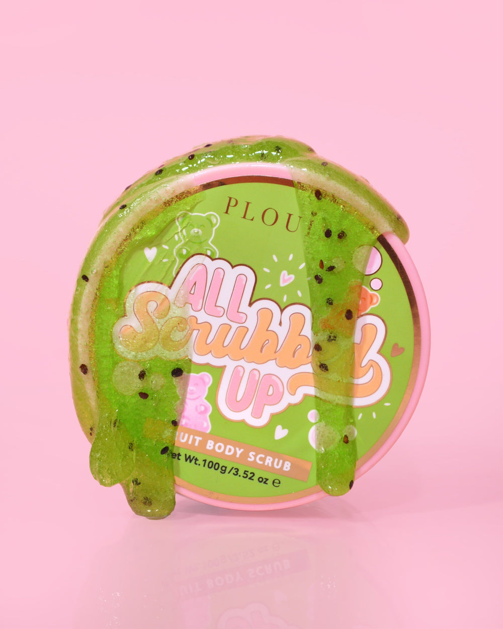 Ein Behälter mit P.Louise All Scrubbed Up Body Scrub mit der Aufschrift „Candy Bears“ auf rosa Hintergrund, wobei das Produkt als grünes Gel erscheint