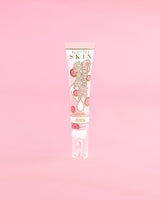 Tubo de P. Louise Dose Of Dreams Vitamin C Brightening Eye Cream sobre un fondo rosa