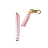 Mini delineador de labios tipo llavero de P.Louise en rosa con la marca "Rich Teal" sobre un fondo rosa claro