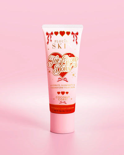 Tubo rosa de crema corporal brillante P.Louise The Glow Down con aroma a costa de coco sobre un fondo rosa