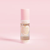 Una botella de spray rosa con la etiqueta 'P.Louise SKIN' con una representación de un corazón y algunos elementos florales, que contiene un spray fijador hidratante.
