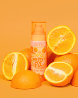 Una botella naranja de P. Louise Fruity Fix Vitamin C Set Spray con un fondo naranja rodeado de rodajas de naranja fresca.