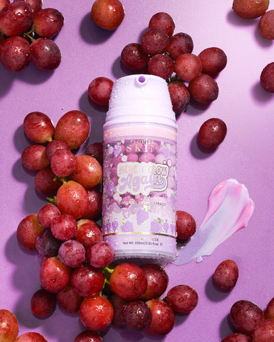Lila Flasche P. Louise Here I Glow Again Grape Recovery Mask, umgeben von Trauben auf violettem Hintergrund