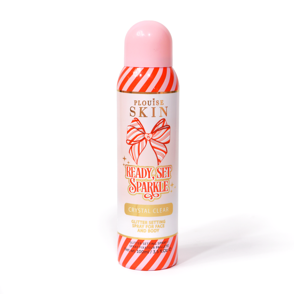 Eine Flasche P. Louise Ready Set Sparkle Christmas Glitter Setting Spray mit roten und rosa Streifen auf der Flasche und einer rot-rosa gestreiften Schleife vor weißem Hintergrund