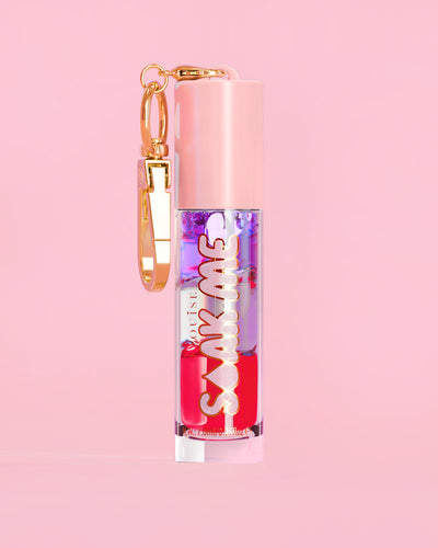 P. Louise Soak Me Lippenöl mit buntem Schichtöl in einer rosa Tube mit goldenem Verschluss auf rosa Hintergrund
