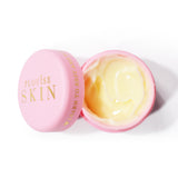 Un frasco abierto de color rosa de P.Louise Give It A Rest Eye Cream que muestra el humectante de color amarillo en el interior
