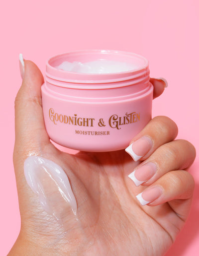 Una mano sosteniendo un frasco rosa de P.Louise Goodnight & Glisten Gel Moisturizer con un poco de humectante visible en el .y